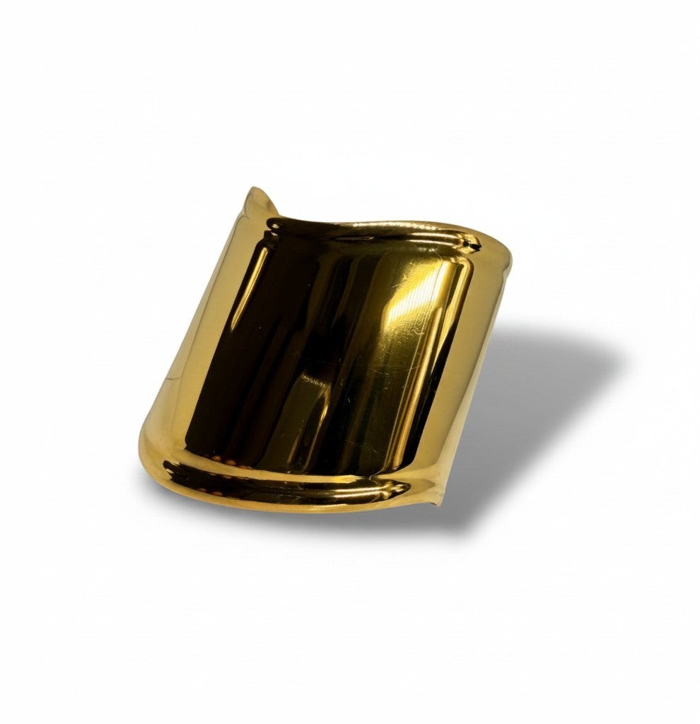 Manchette Majoa en acier inoxydable doré, bracelet ouvert au design sculptural et finition miroir brillante.