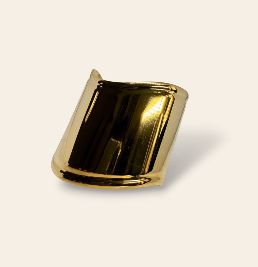 Manchette Majoa dorée en acier inoxydable au design sculptural et finition miroir brillante