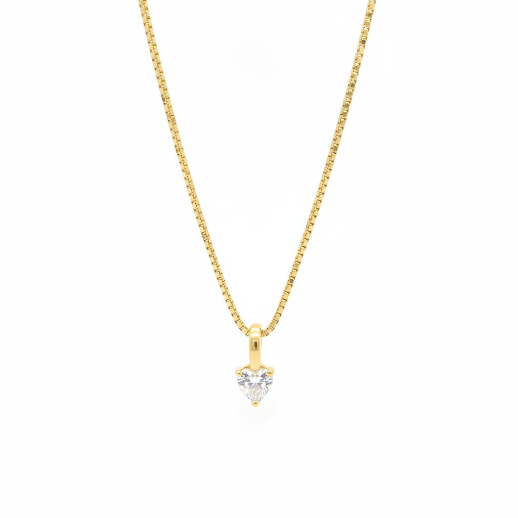 Collier Aura Majoa en or avec pendentif en forme de cœur serti d'une pierre scintillante, style minimaliste.