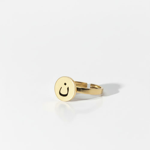 Majoa gold stainless steel ring with black enamel and Arabic letter N engraving. Minimalist design.