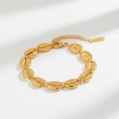 Confectionné avec un souci du détail exceptionnel, chaque coquillage poli s'assemble pour créer un bijou délicat et captivant. La finition dorée, chaude et brillante, apporte une touche de luxe, idéale pour une journée décontractée à la plage comme pour une soirée sophistiquée. Léger et confortable, ce bracelet est conçu pour devenir un bijou intemporel, évoquant l'esprit de l'été et la beauté naturelle de l'océan.
