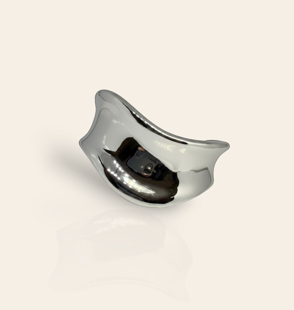 Manchette Rempart Majoa en acier inoxydable argenté, bracelet ouvert sculptural à la finition polie miroir.