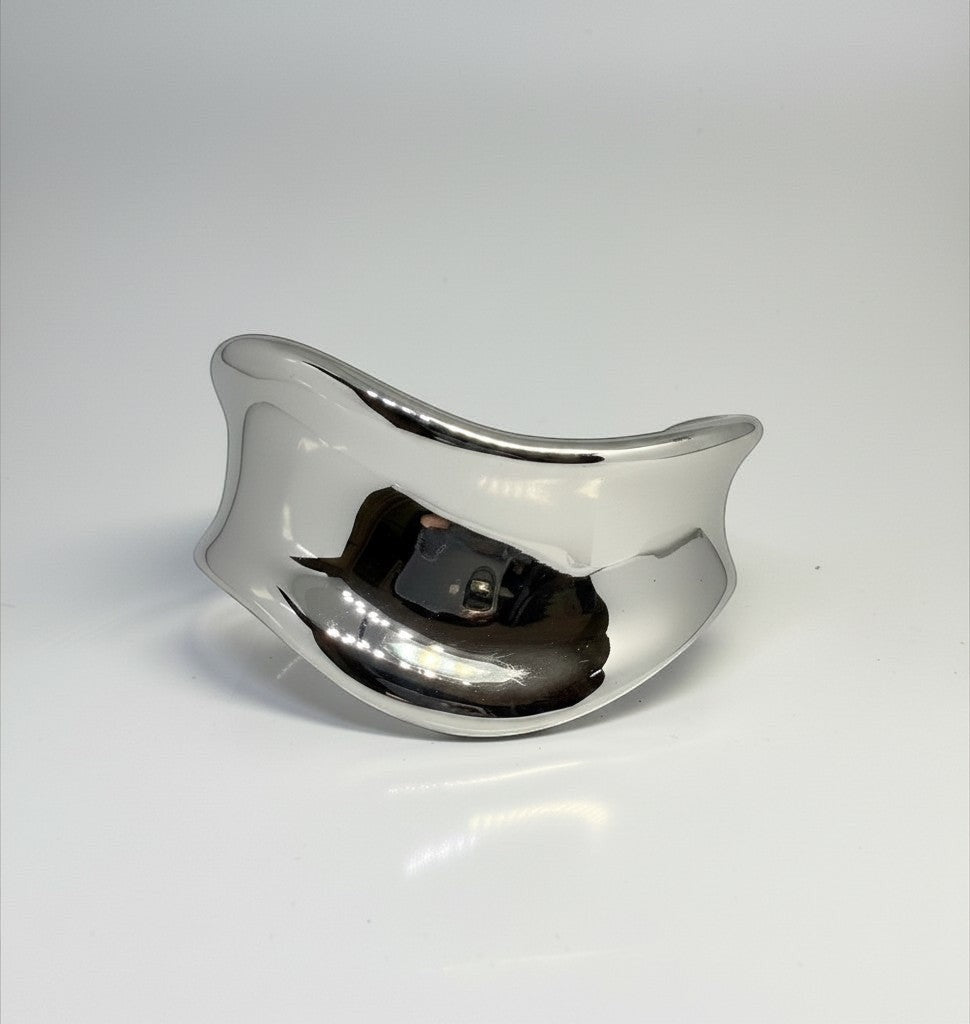 Manchette Rempart Majoa en acier inoxydable argenté, bracelet ouvert sculptural à la finition polie miroir.